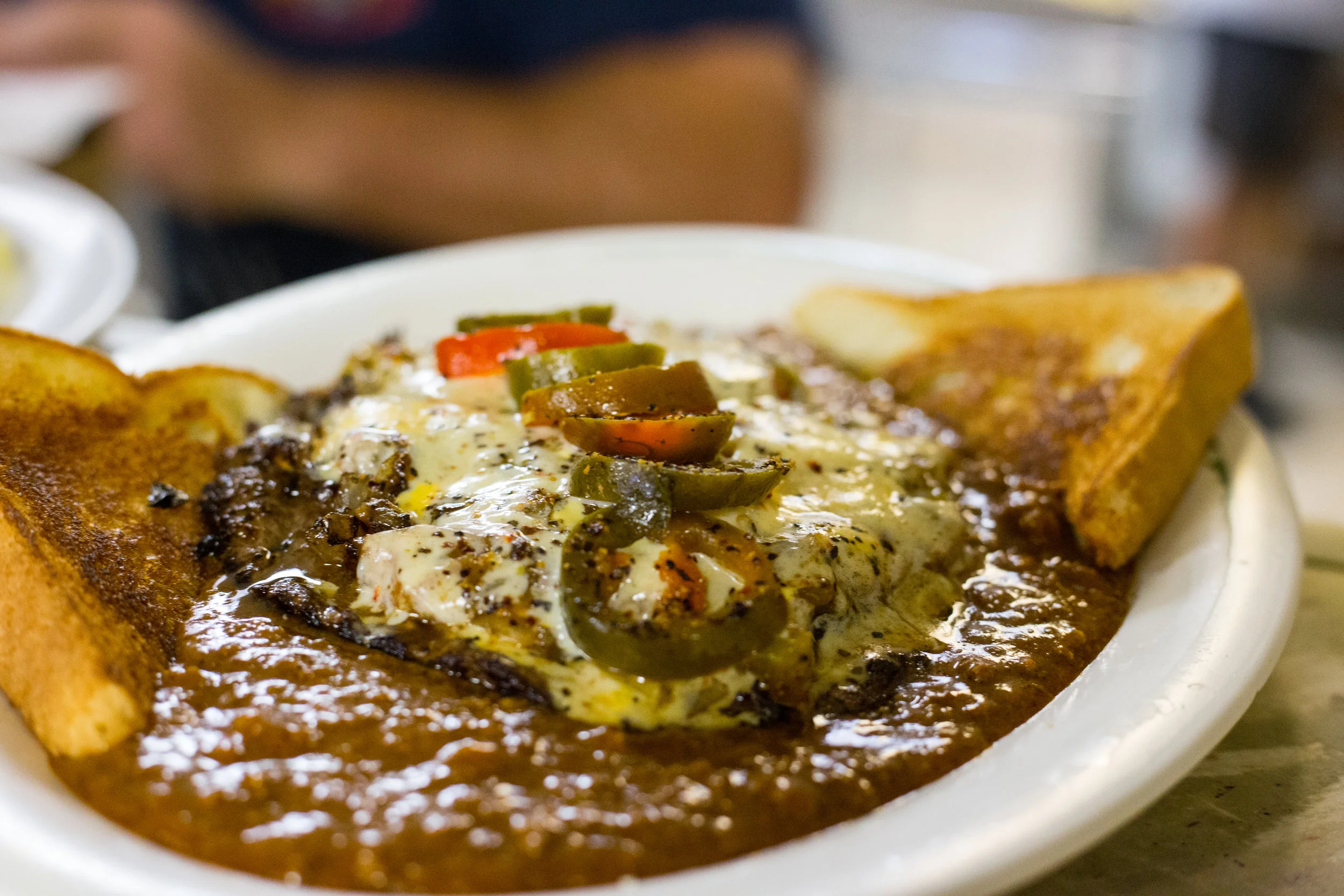 Cheesy enchiladas smothered in sauce with jalapeños