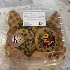 Two freshly baked cookies on a marble surface, showcasing a golden-brown color.