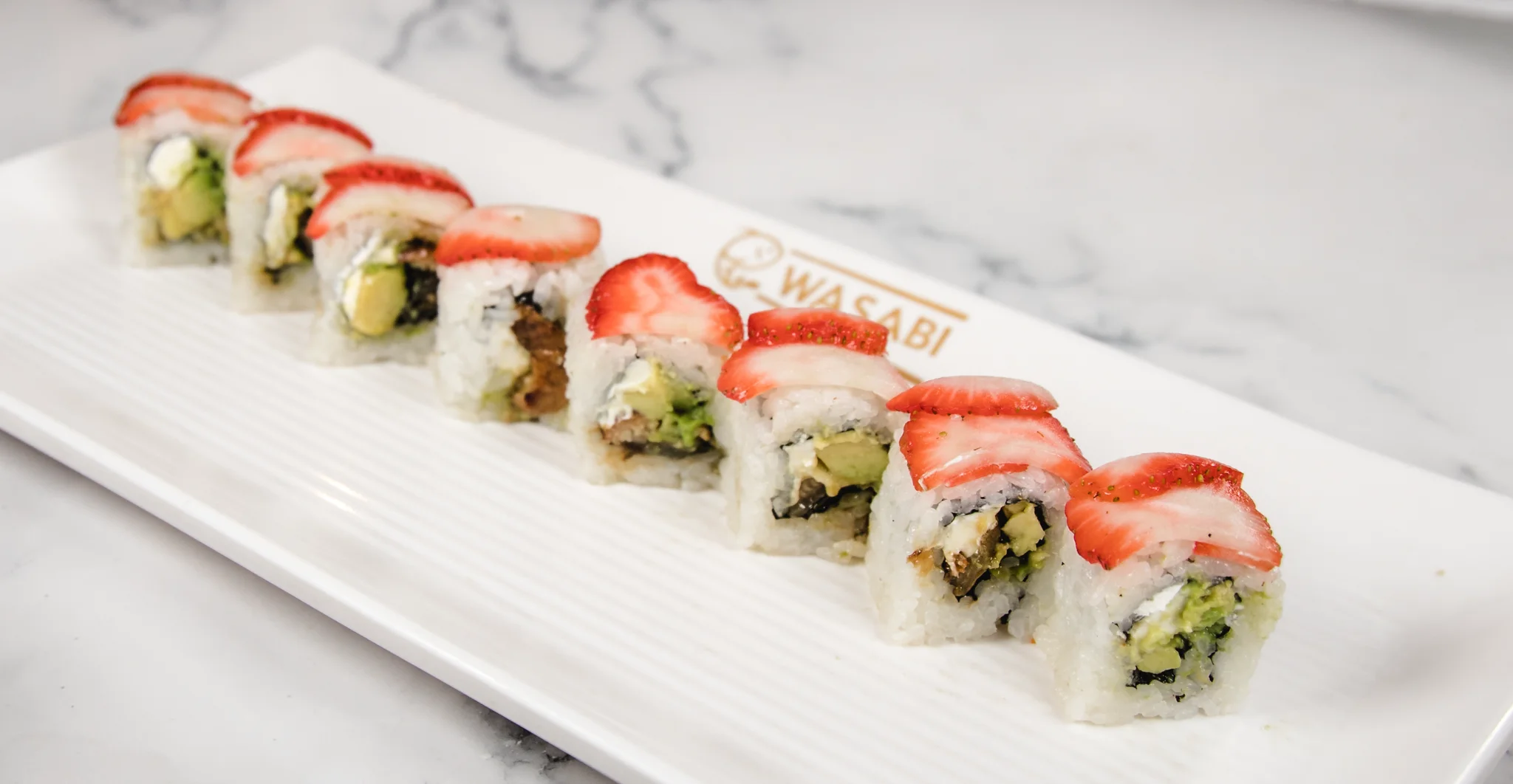 Japanese sushi roll topped with fresh strawberries