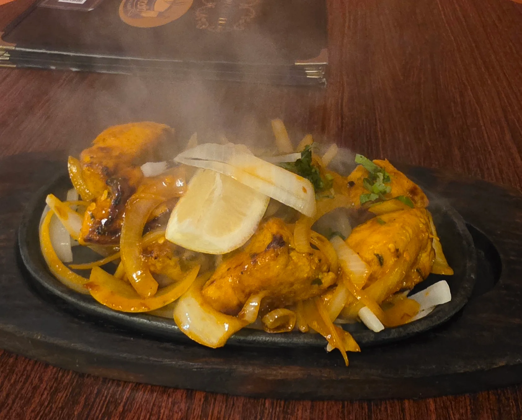 Chicken tikka kebab with onions and lemon at Sugandh