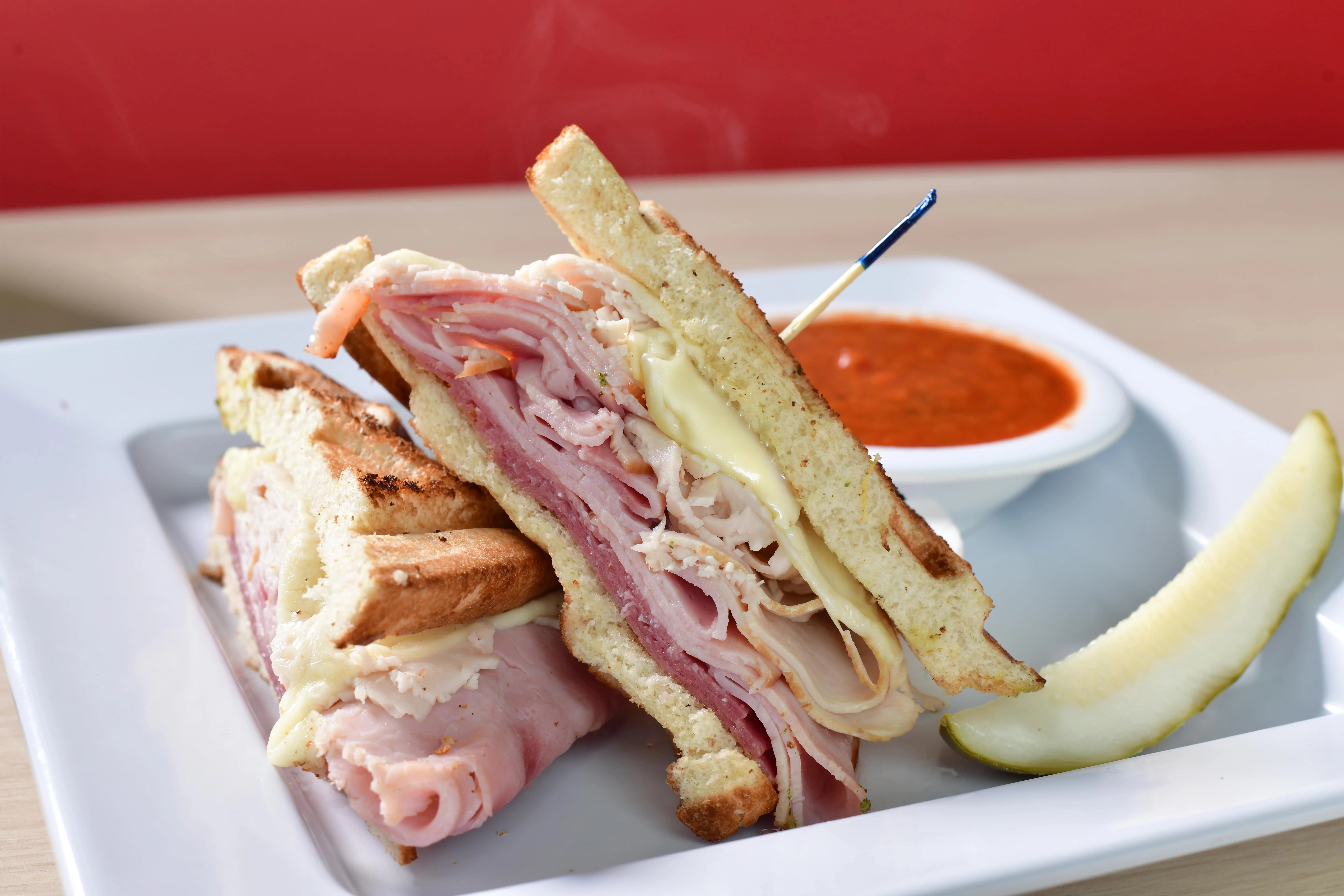 Classic Italian panini with ham and cheese served with marinara sauce