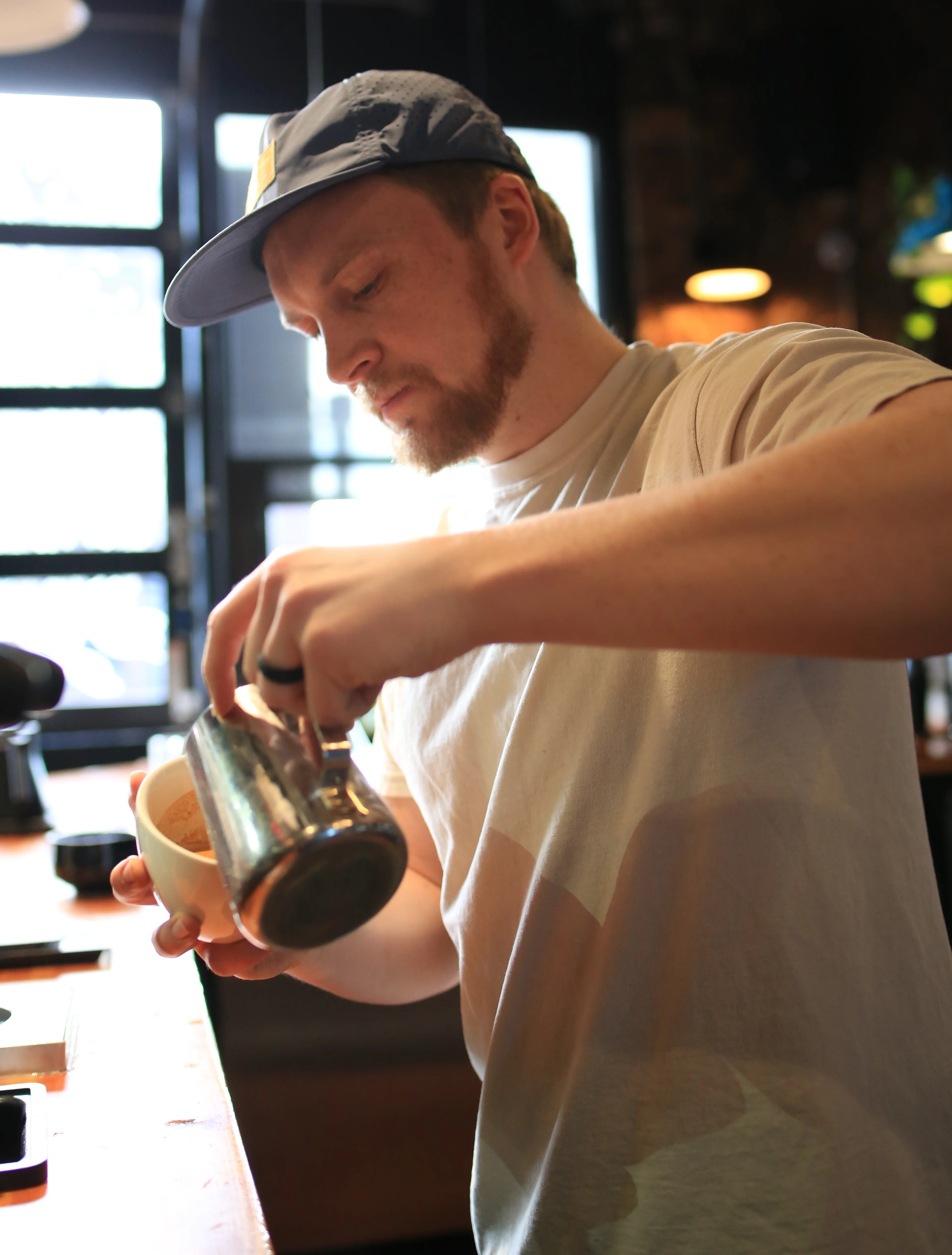 Barista pouring coffee at a modern café