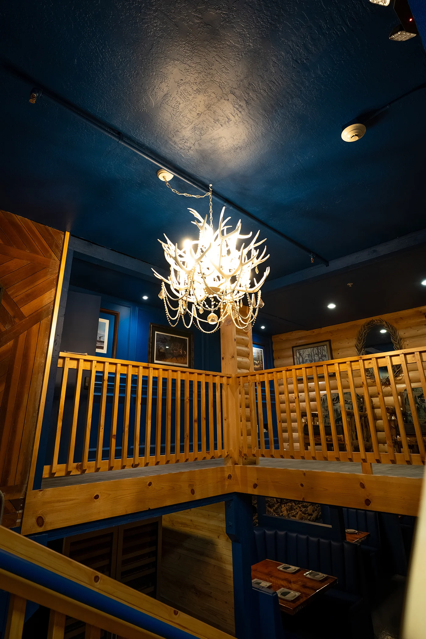 Elegant restaurant interior with antler chandelier and wooden accents