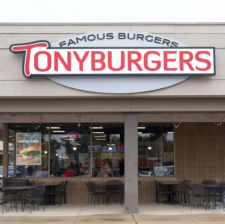 Exterior view of Tony Burgers restaurant with outdoor seating and open sign
