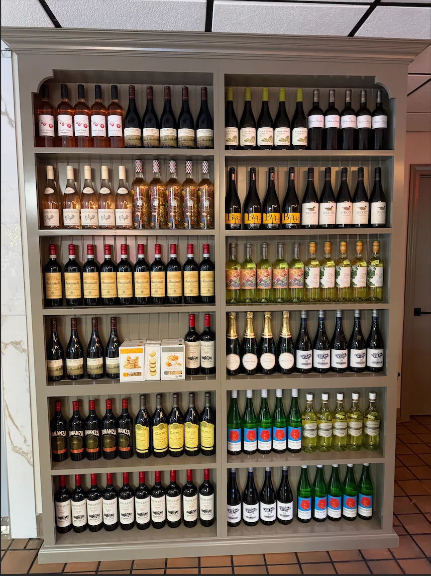 A display of various wine bottles arranged on shelves in a restaurant.