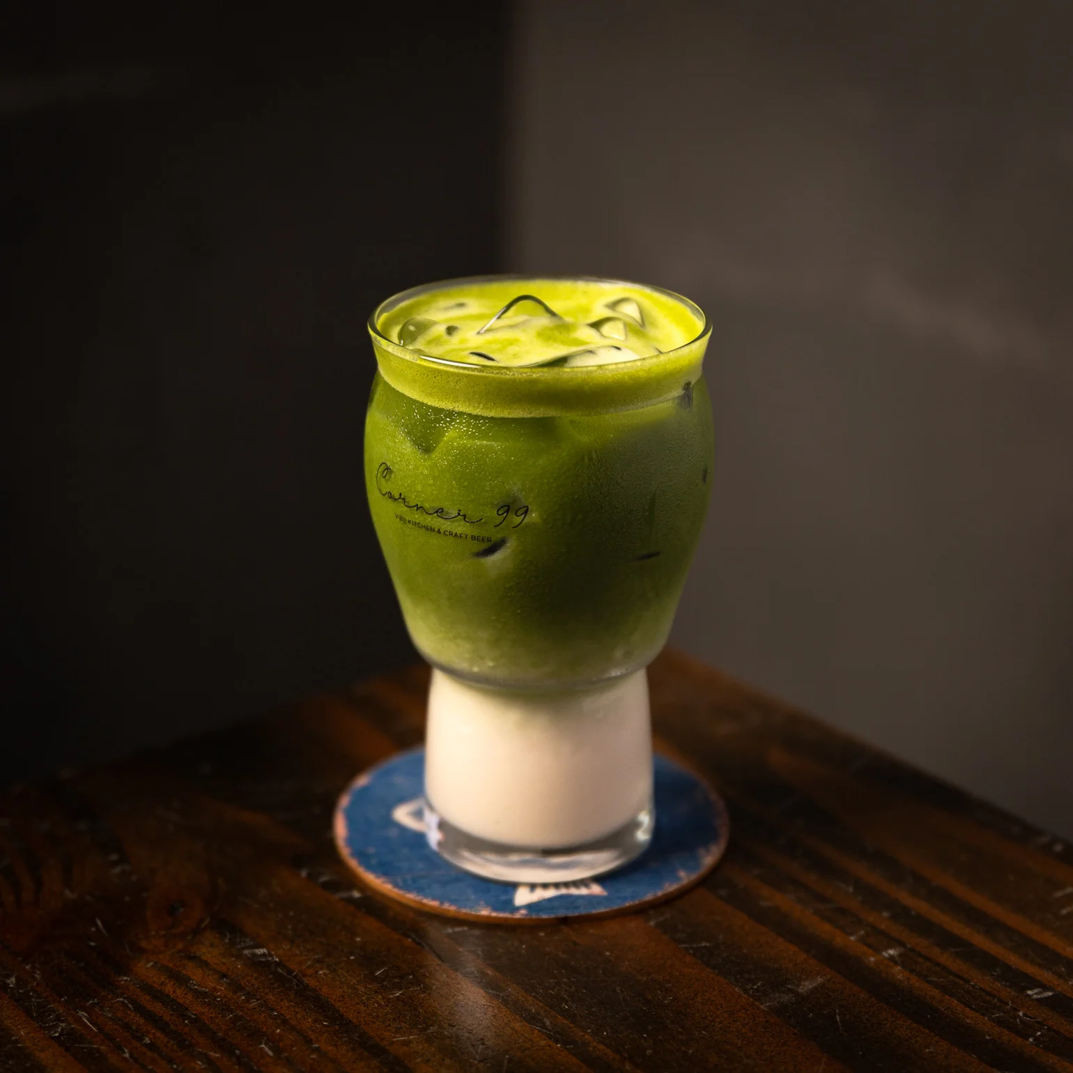Iced matcha latte with milk served in a stylish glass