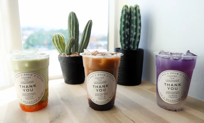 Colorful iced beverages in clear cups on a wooden table