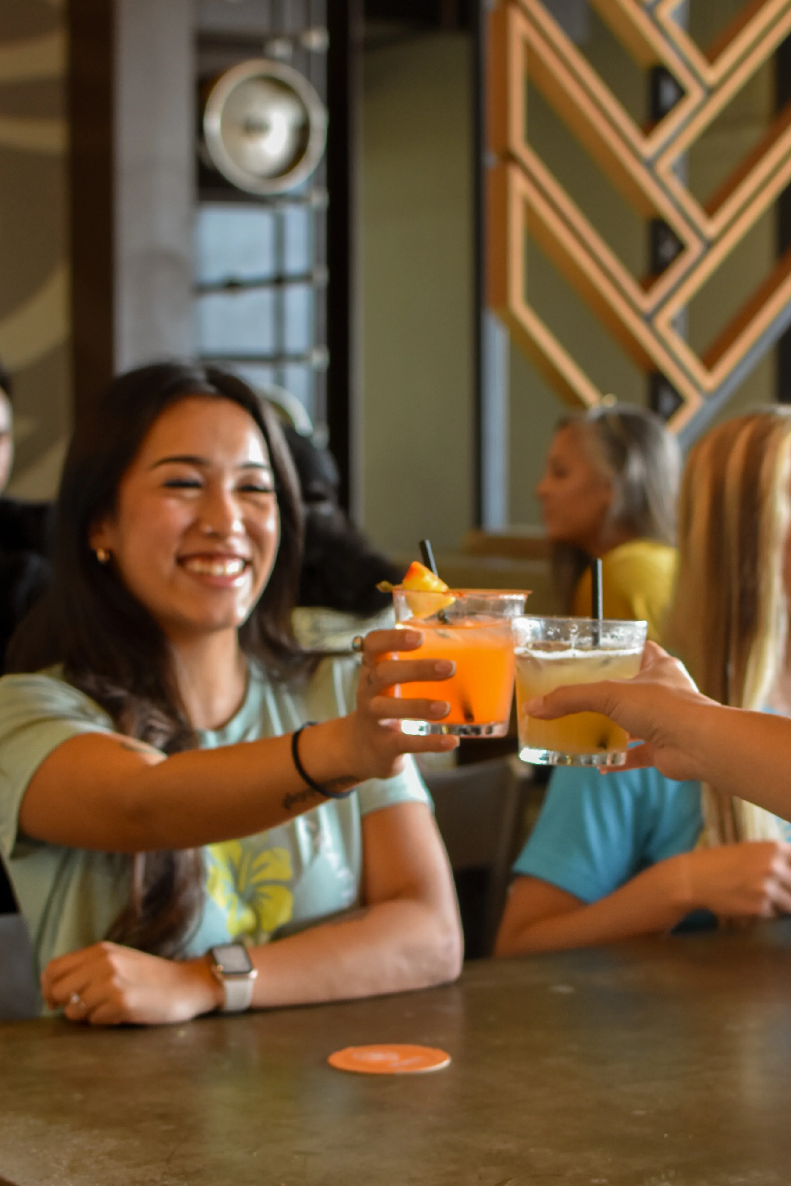 Friends toasting cocktails at a lively restaurant