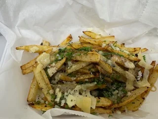 Loaded French fries topped with cheese and herbs