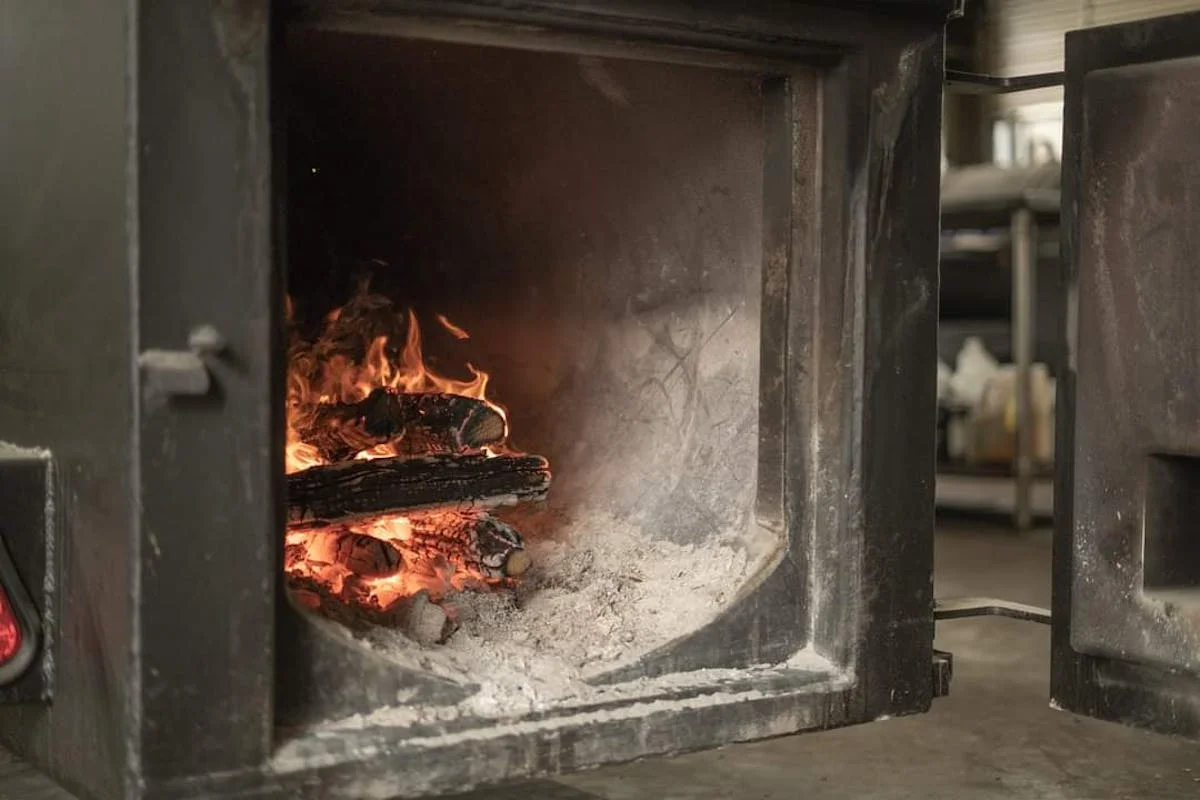 Wood-fired oven with glowing embers and logs