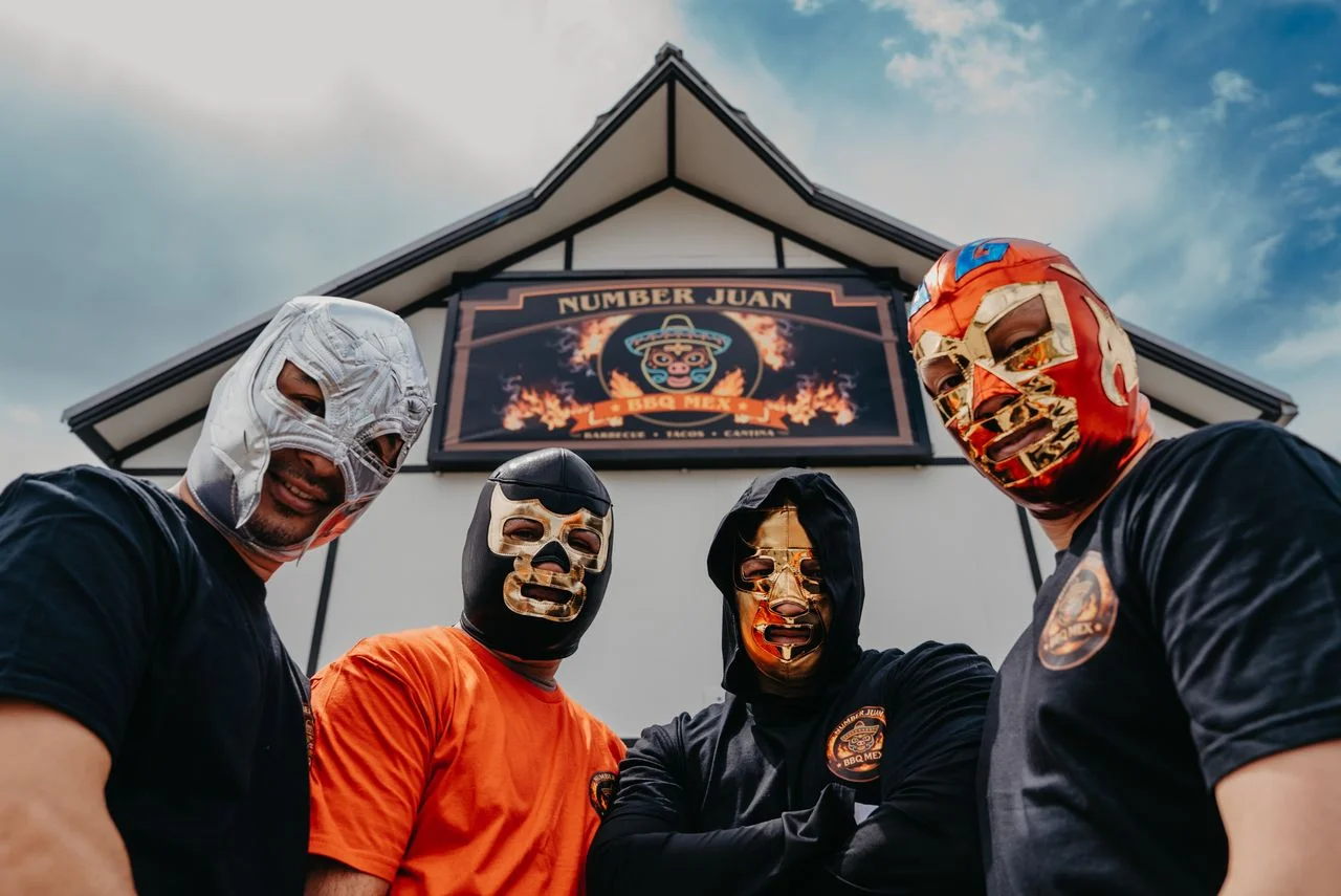 Group of masked chefs outside Number Juan BBQ Mex restaurant