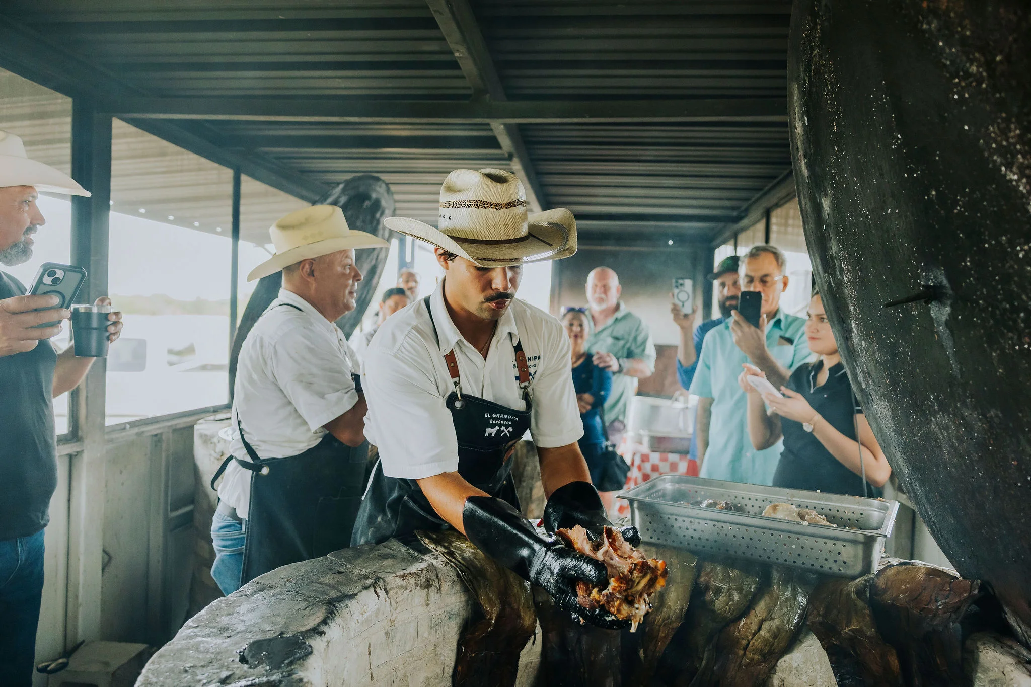 Chef serving traditional barbacoa in a rustic kitchen setting