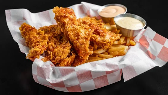 Crispy fried chicken tenders with fries and dipping sauces