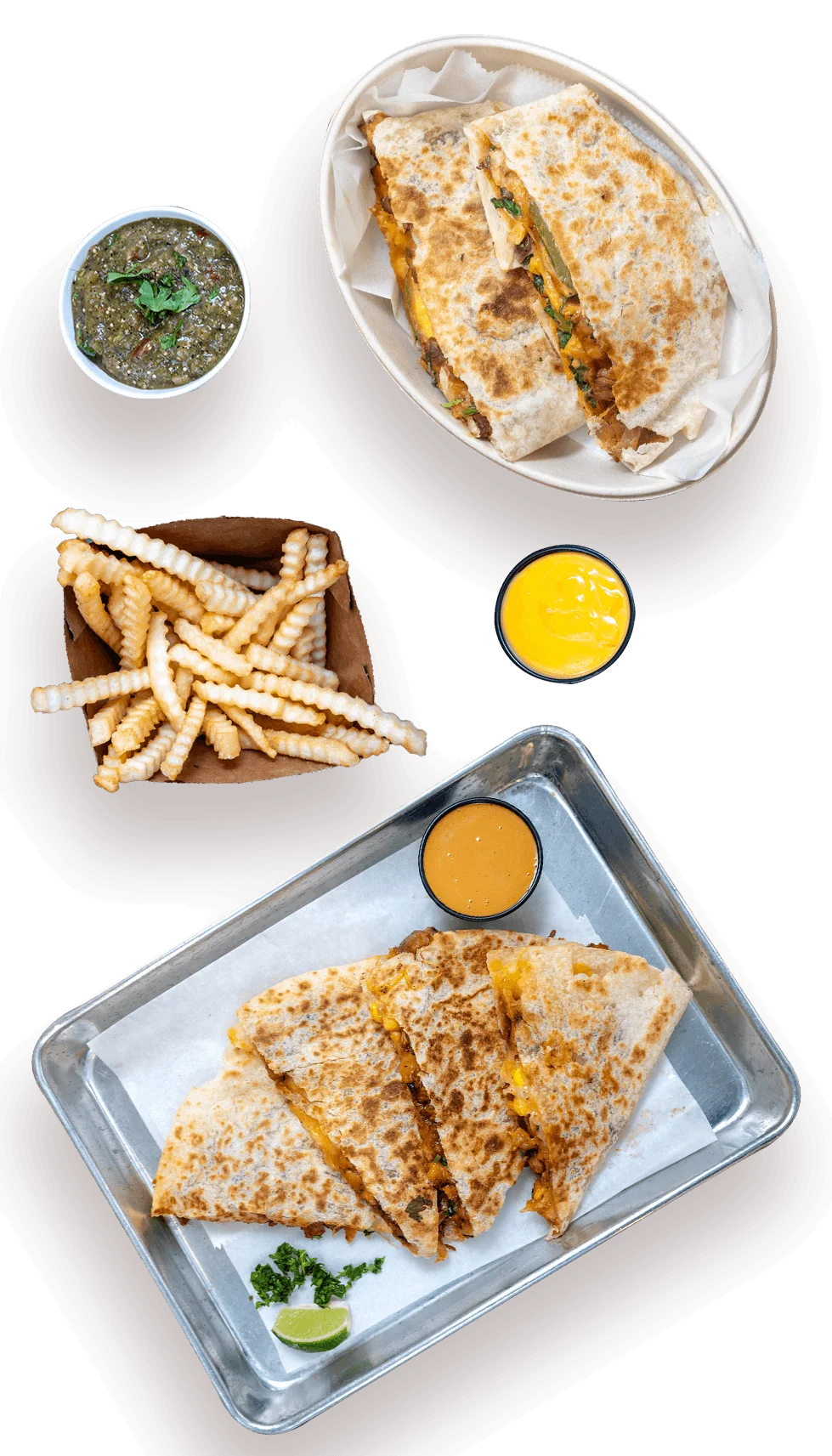 A spread of various foods on a wooden table, including tacos, nachos, quesadillas, and different dipping sauces.