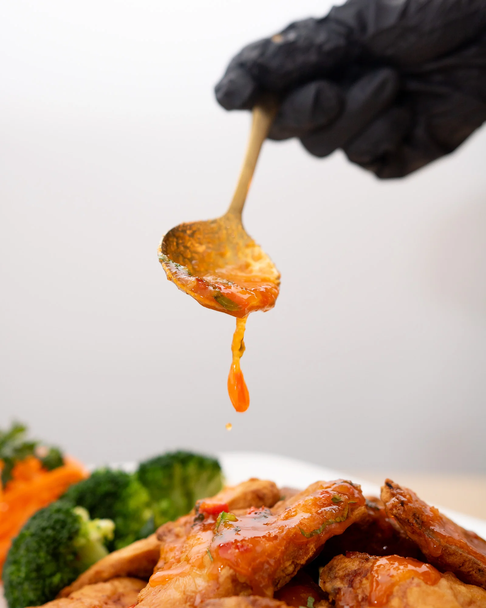 A chef pouring sweet and sour sauce