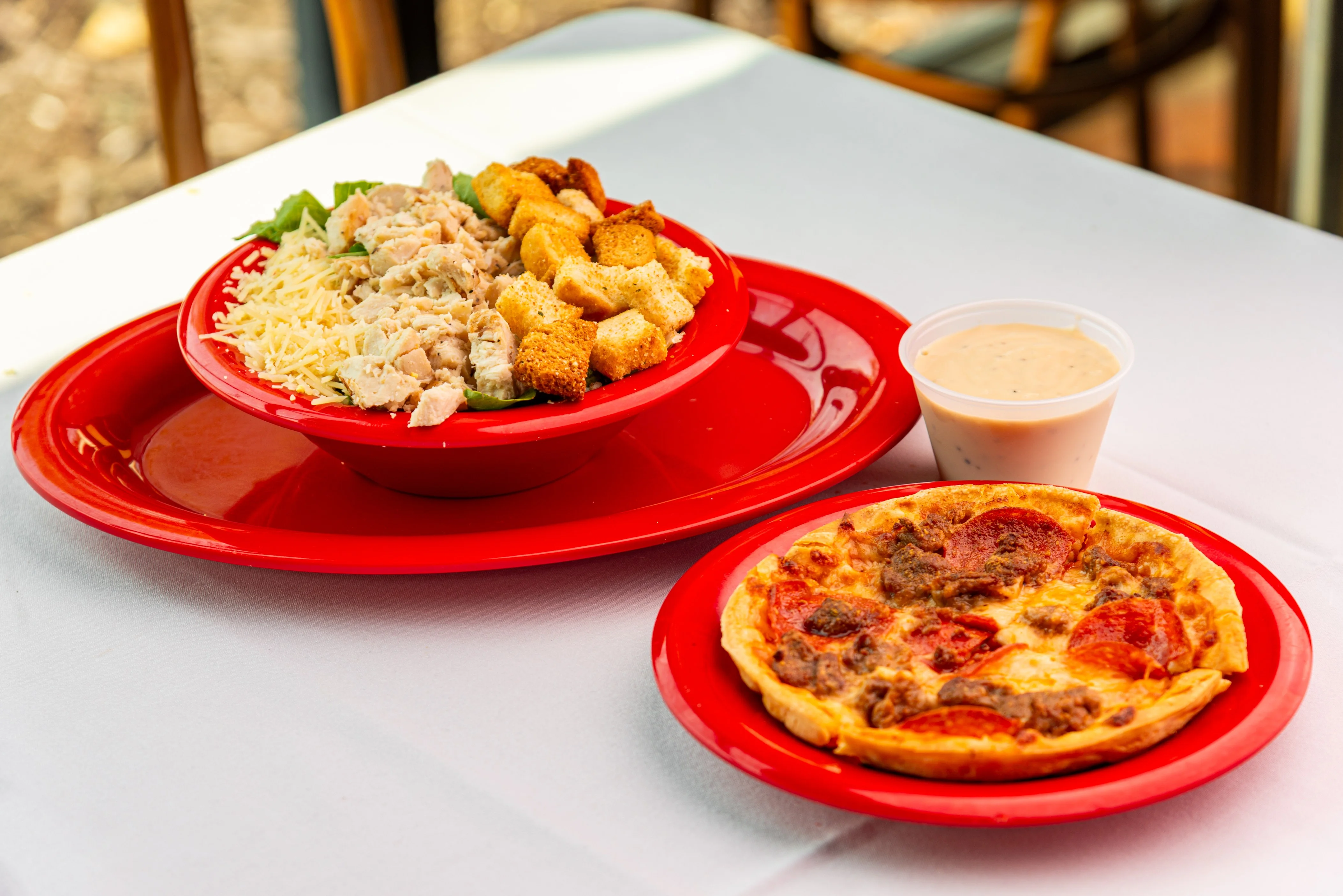 Caesar salad with grilled chicken and pepperoni pizza