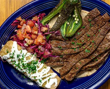 Grilled carne asada with tortillas and fresh toppings