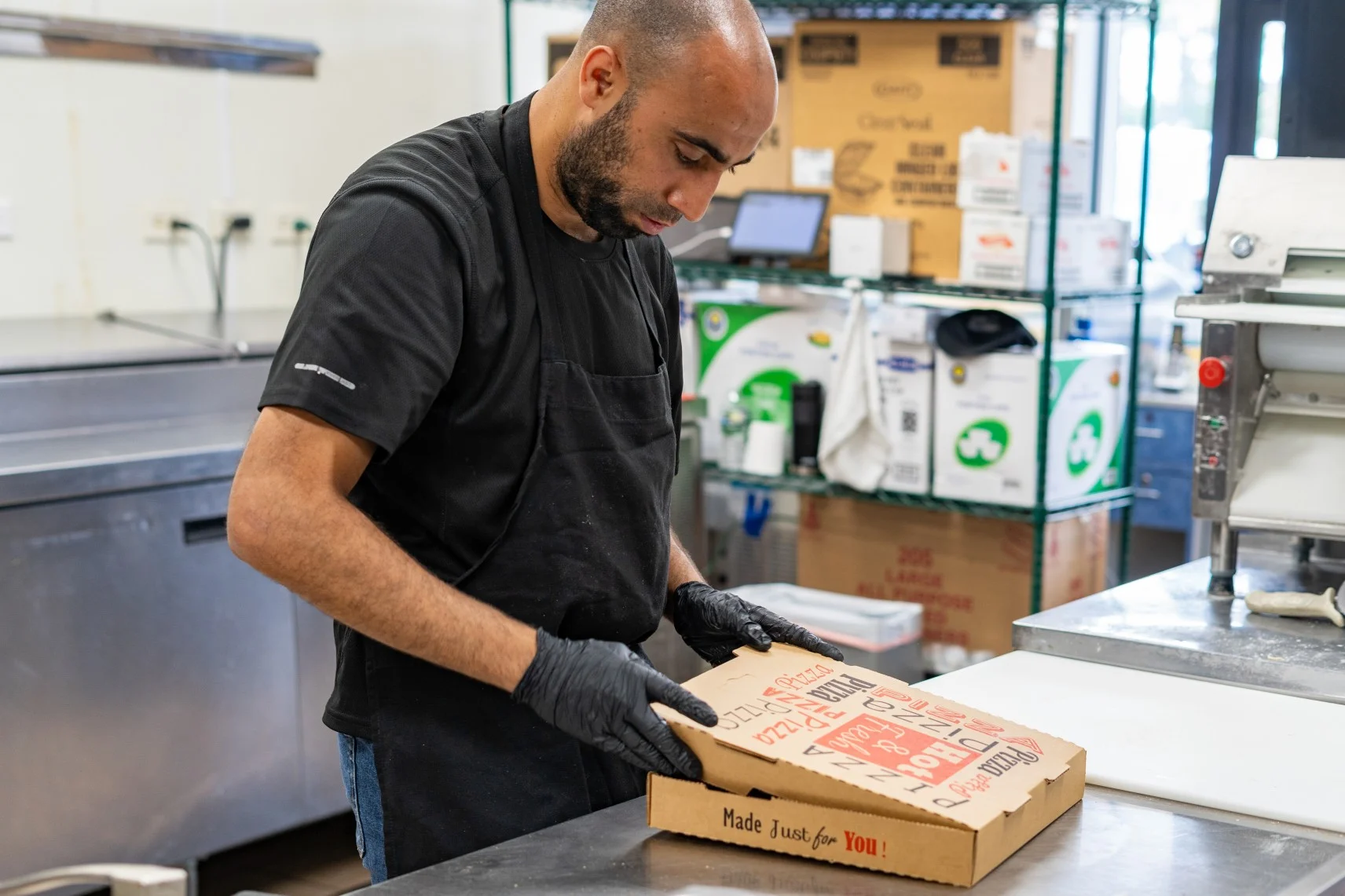 Pizza box being prepared in a restaurant kitchen