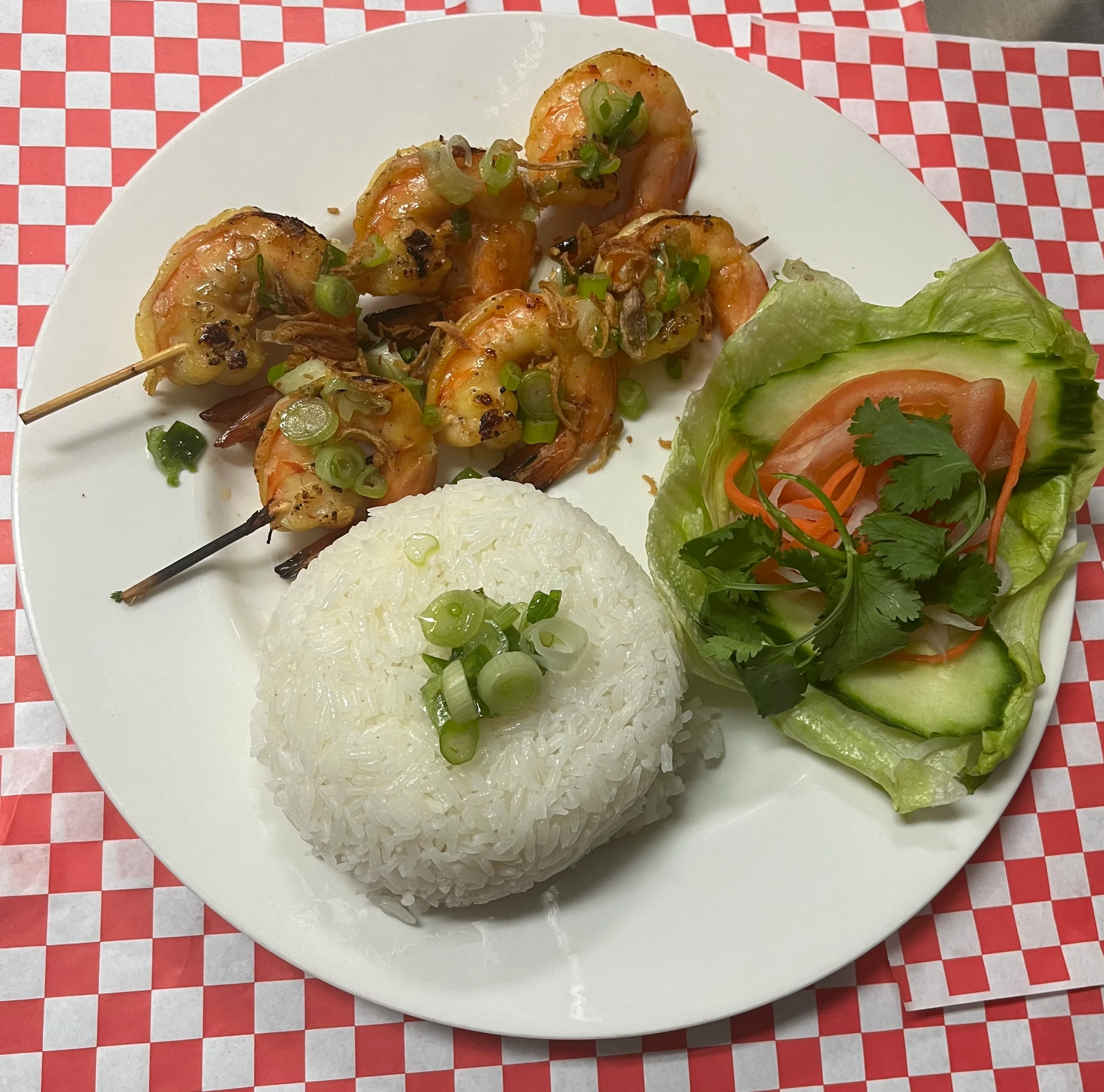 Grilled Vietnamese shrimp skewers with rice and fresh vegetables