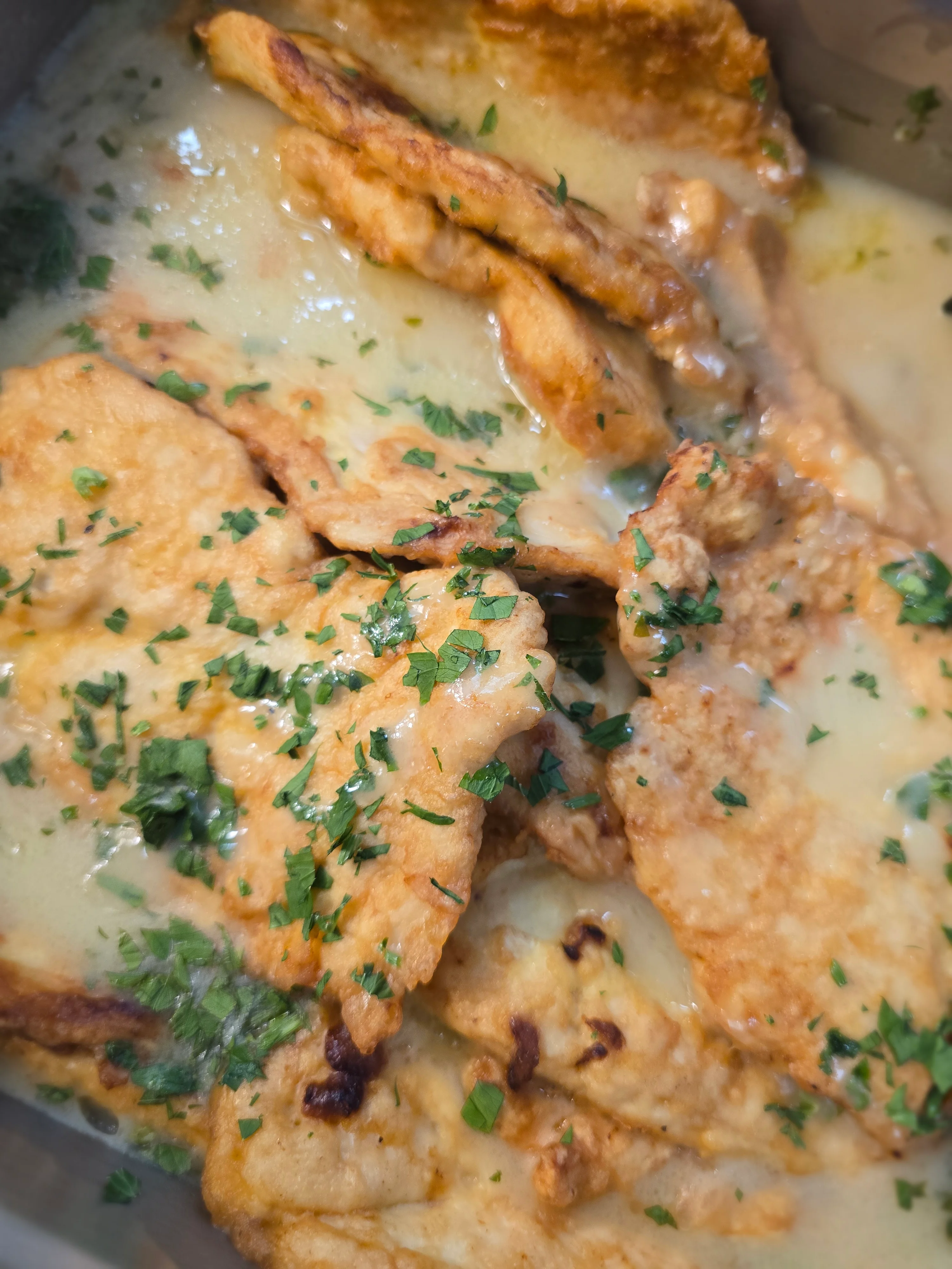 Crispy fried fish in creamy sauce with herbs