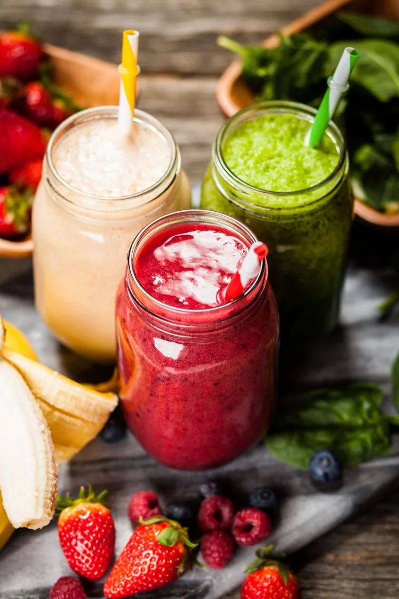 Colorful smoothie jars with fresh fruits and greens