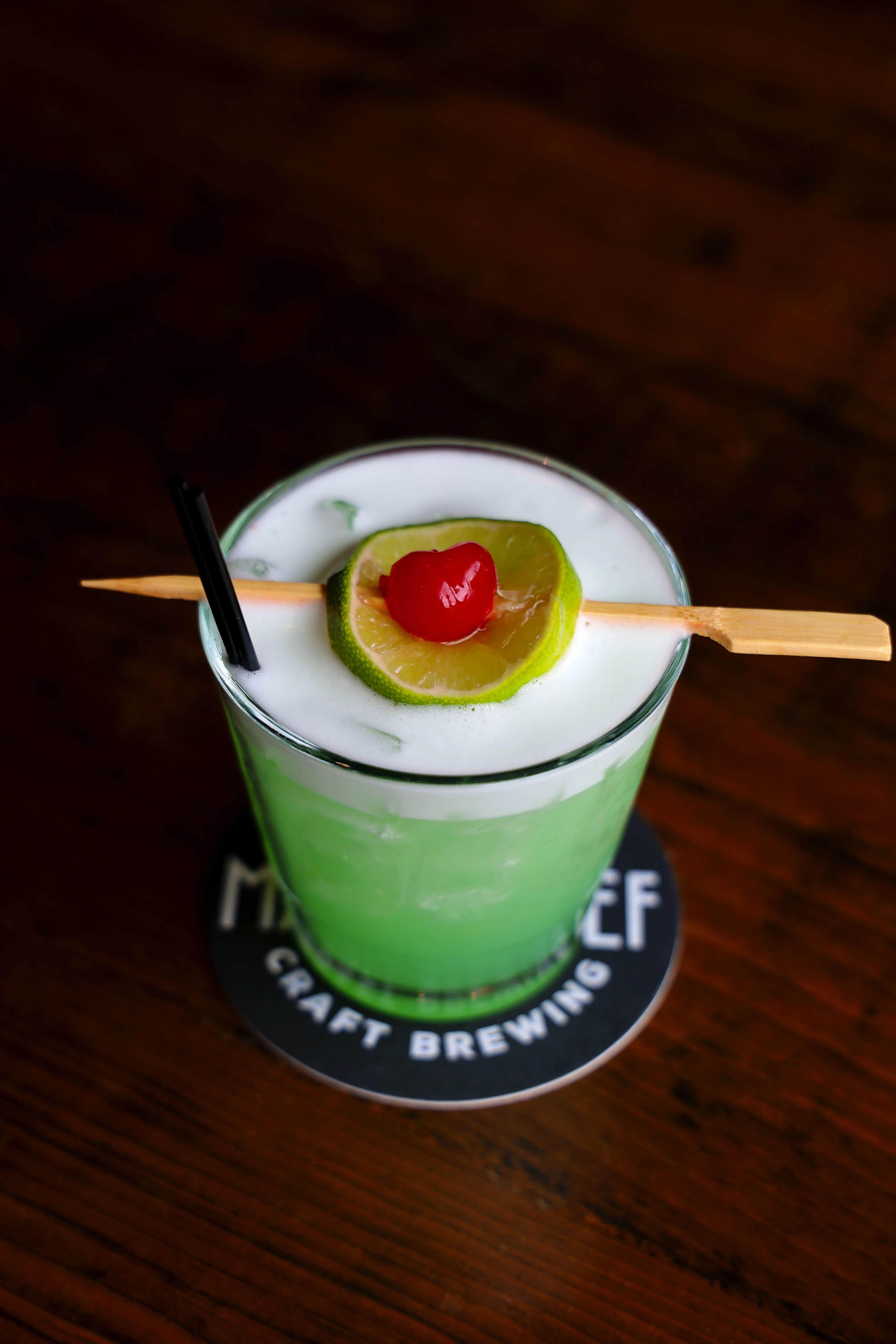 Vibrant cocktail with lime and cherry garnish