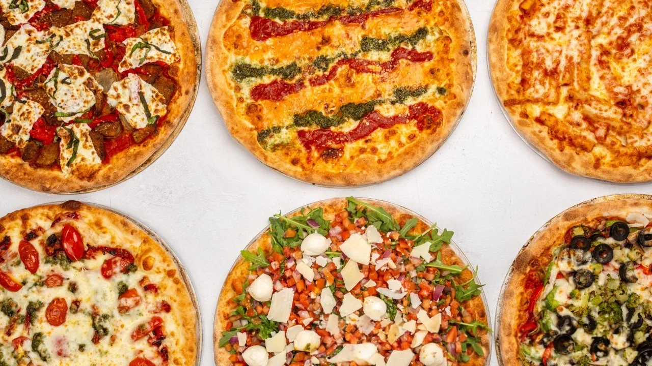 Variety of gourmet pizzas on a wooden table