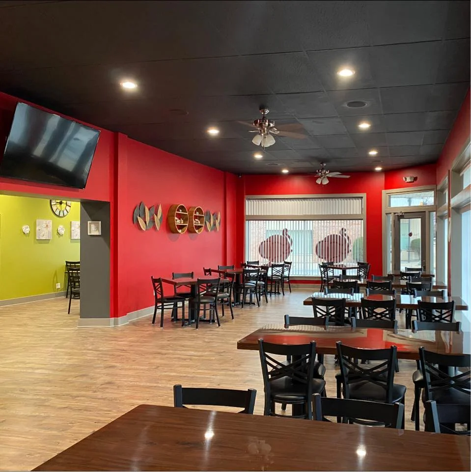 Cozy restaurant interior with vibrant red walls and wooden tables
