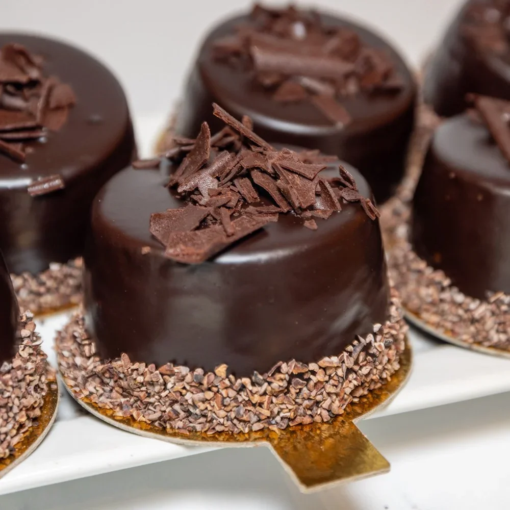 Delicious chocolate tarts arranged on a white plate.
