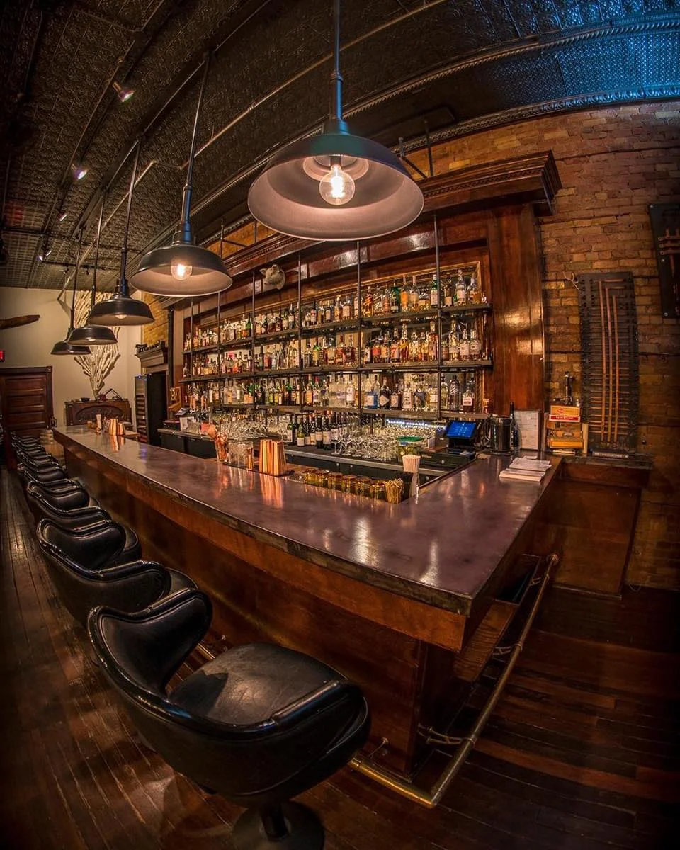 Stylish bar interior with wooden counter and shelves of spirits