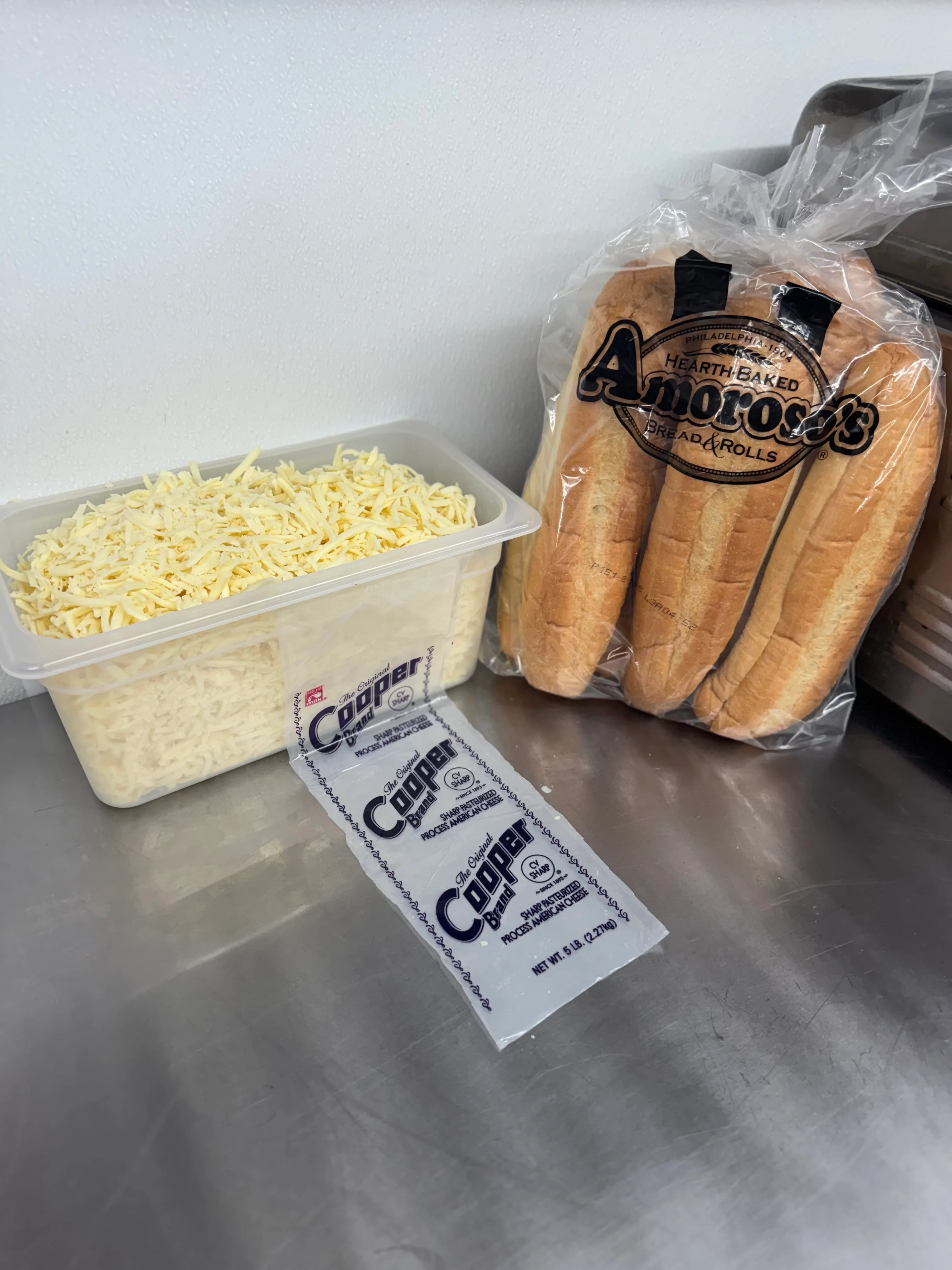 Freshly prepared Italian hoagie ingredients on a stainless steel counter