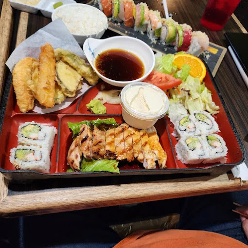 Japanese bento box with sushi, grilled chicken, and tempura