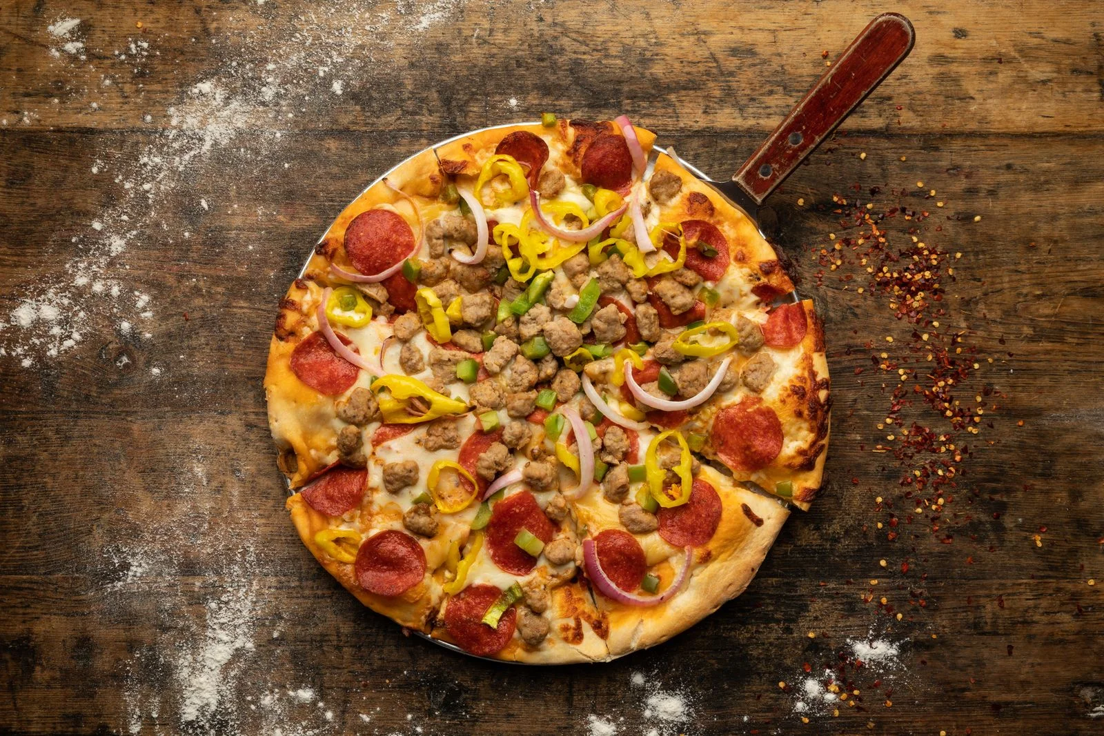 Delicious pizza topped with pepperoni, sausage, and colorful vegetables.