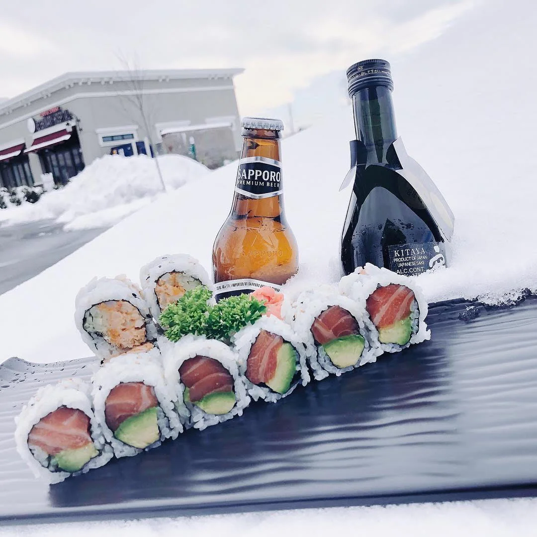 Japanese sushi rolls with Sapporo beer in a snowy setting