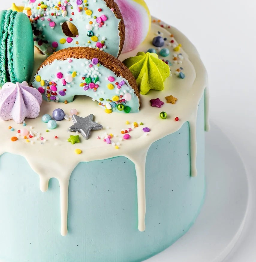 Colorful birthday cake with donuts and macarons