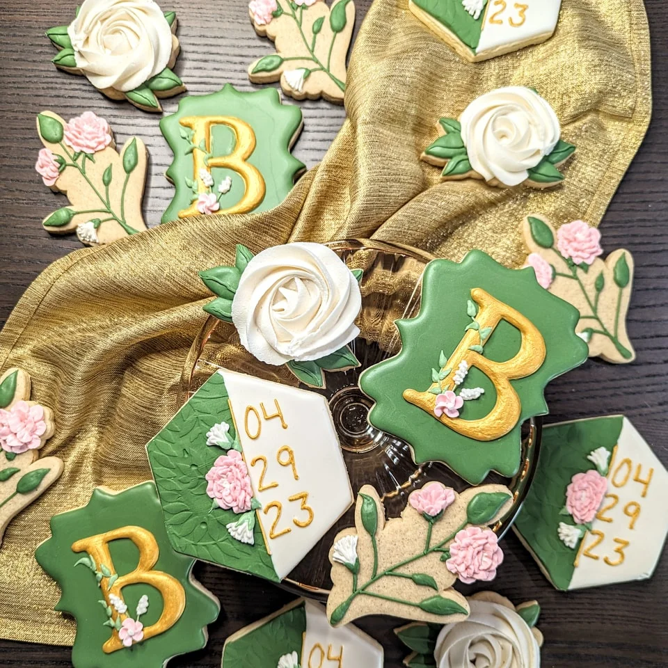 Decorative cookies for a celebration with floral designs and gold accents