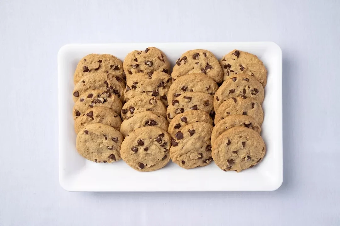 Freshly baked chocolate chip cookies on a white platter