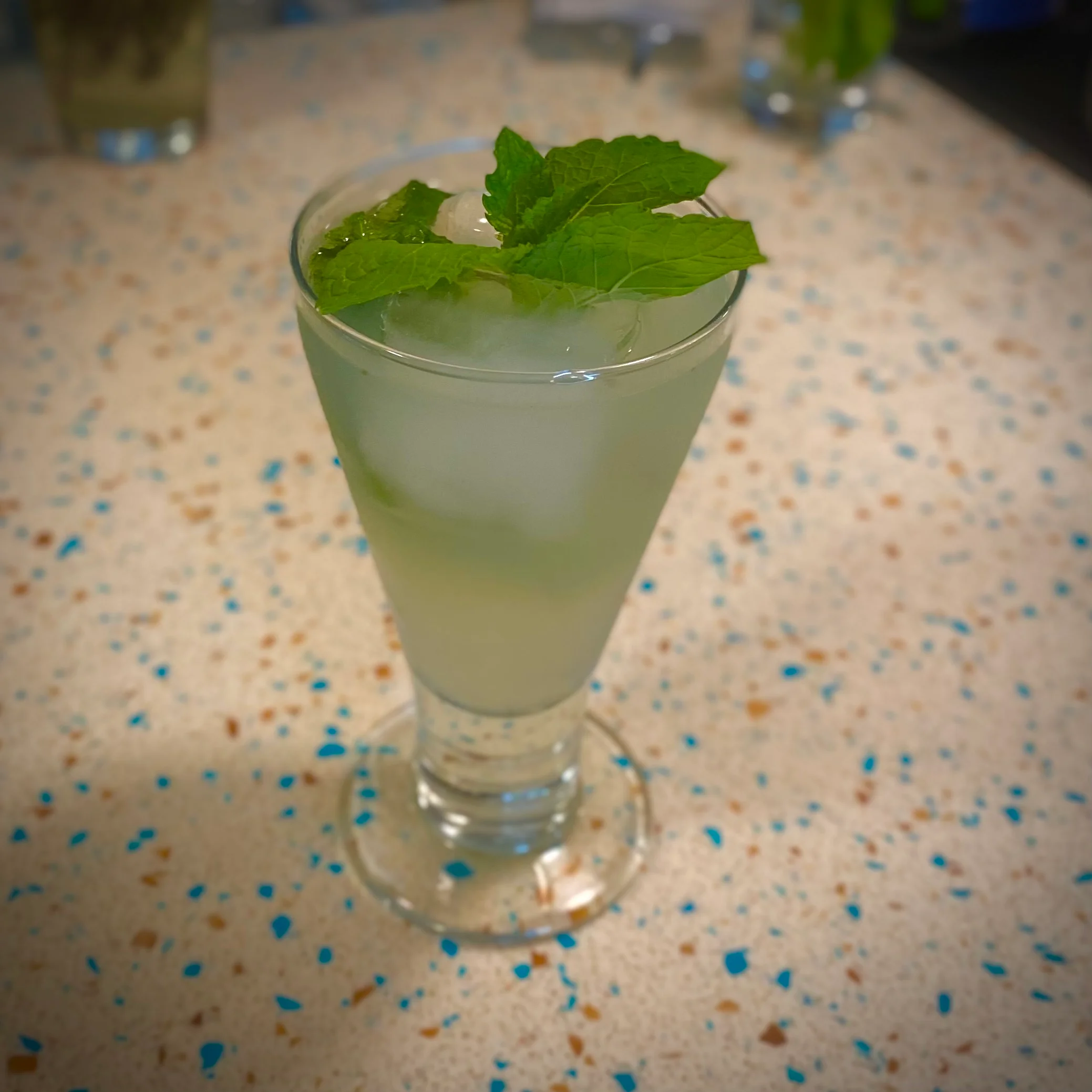 Refreshing mint cocktail with ice in a stemmed glass
