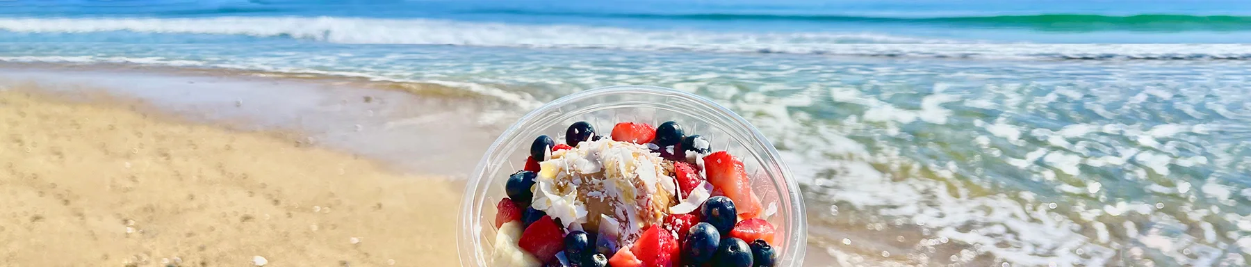 Colorful acai bowl by the beach with fresh fruits