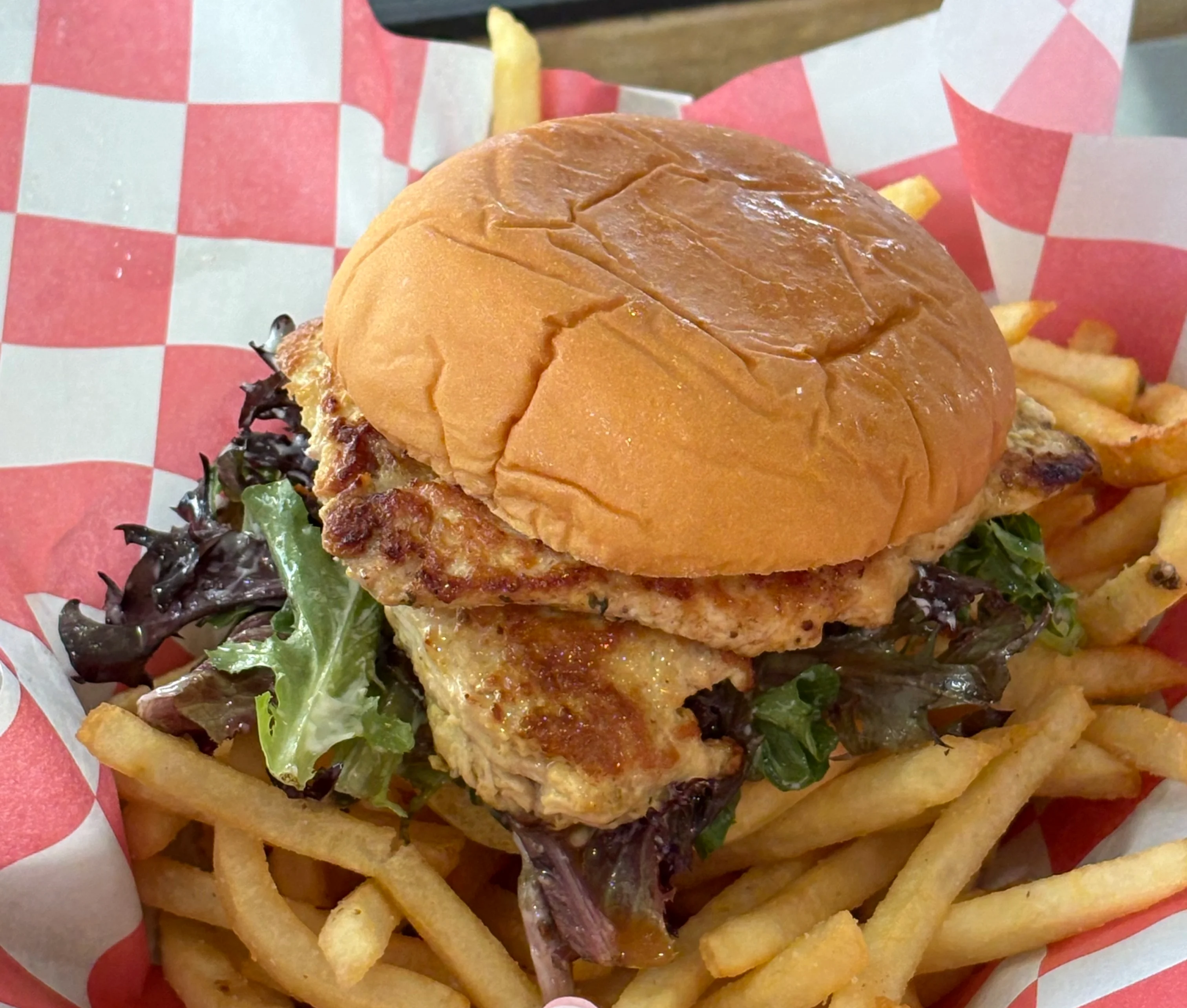 Grilled chicken sandwich with fries in a casual dining setting