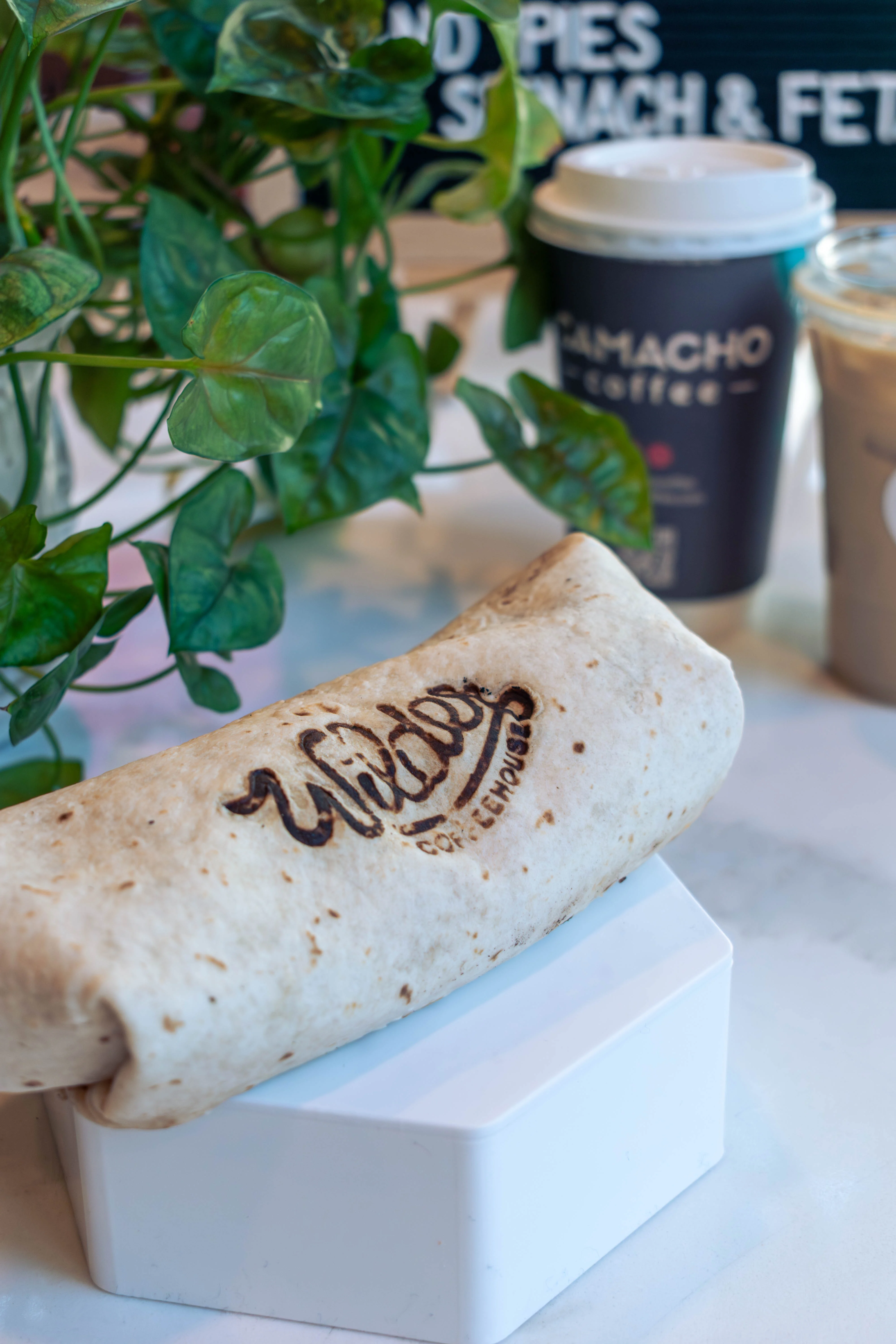A breakfast burrito with the Wilder logo burned into the tortilla
