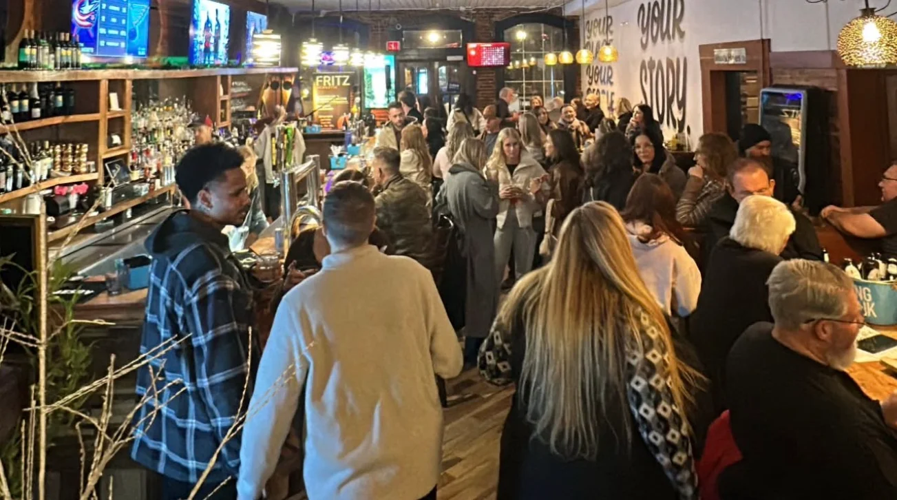 Lively restaurant interior with patrons enjoying drinks and conversation