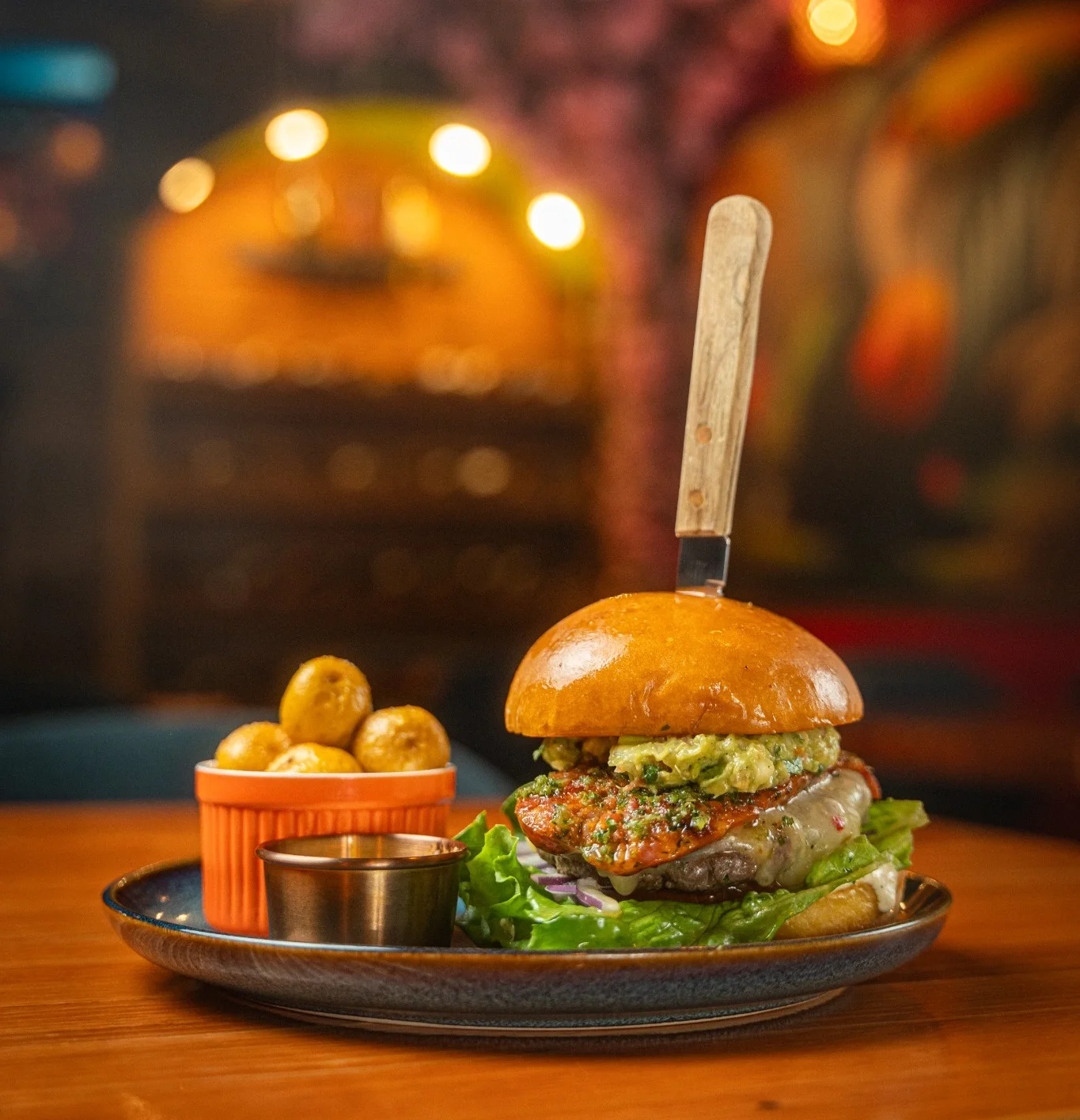 Gourmet burger with avocado and side potatoes