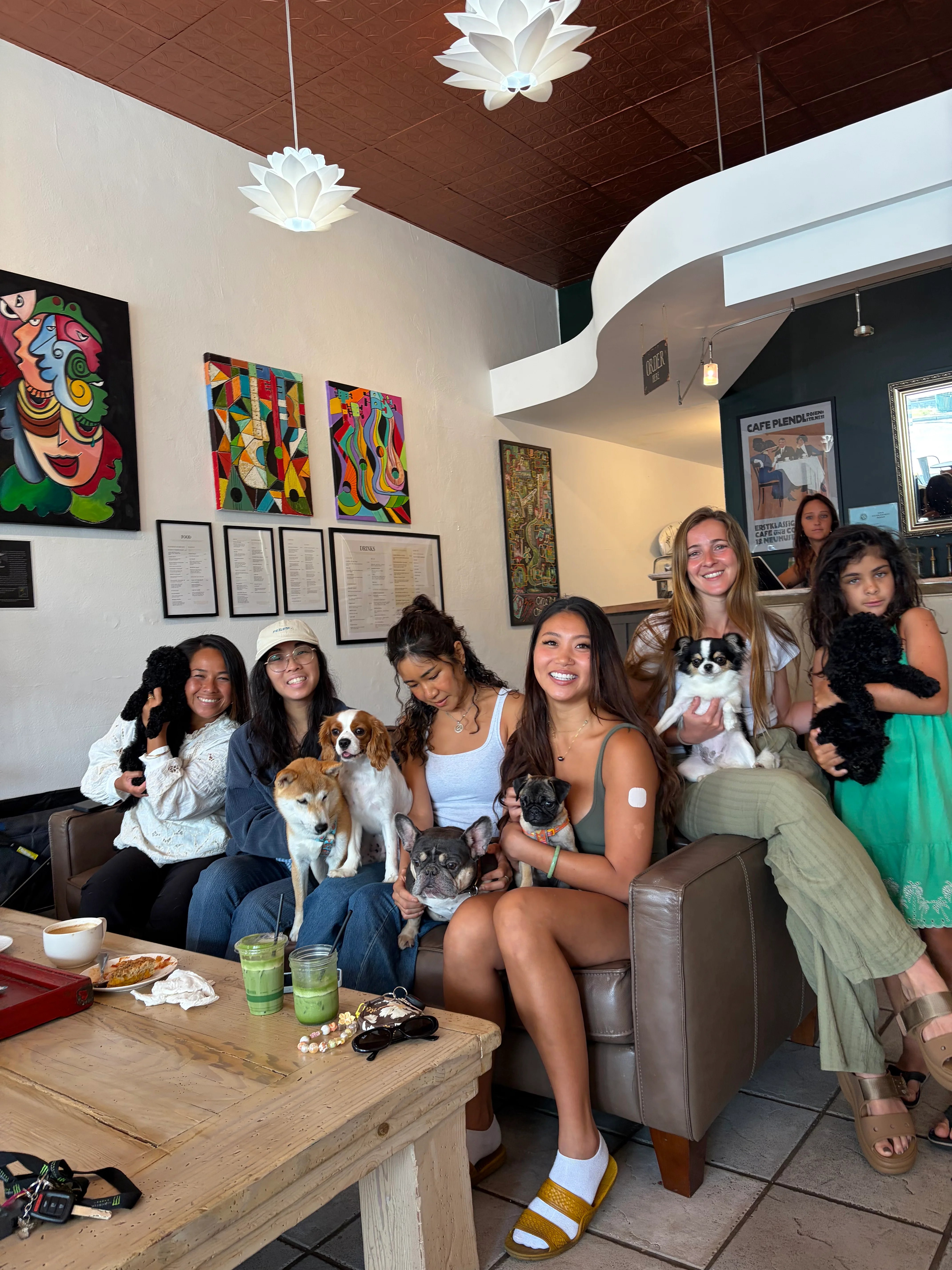 Friends holding puppies on a sofa