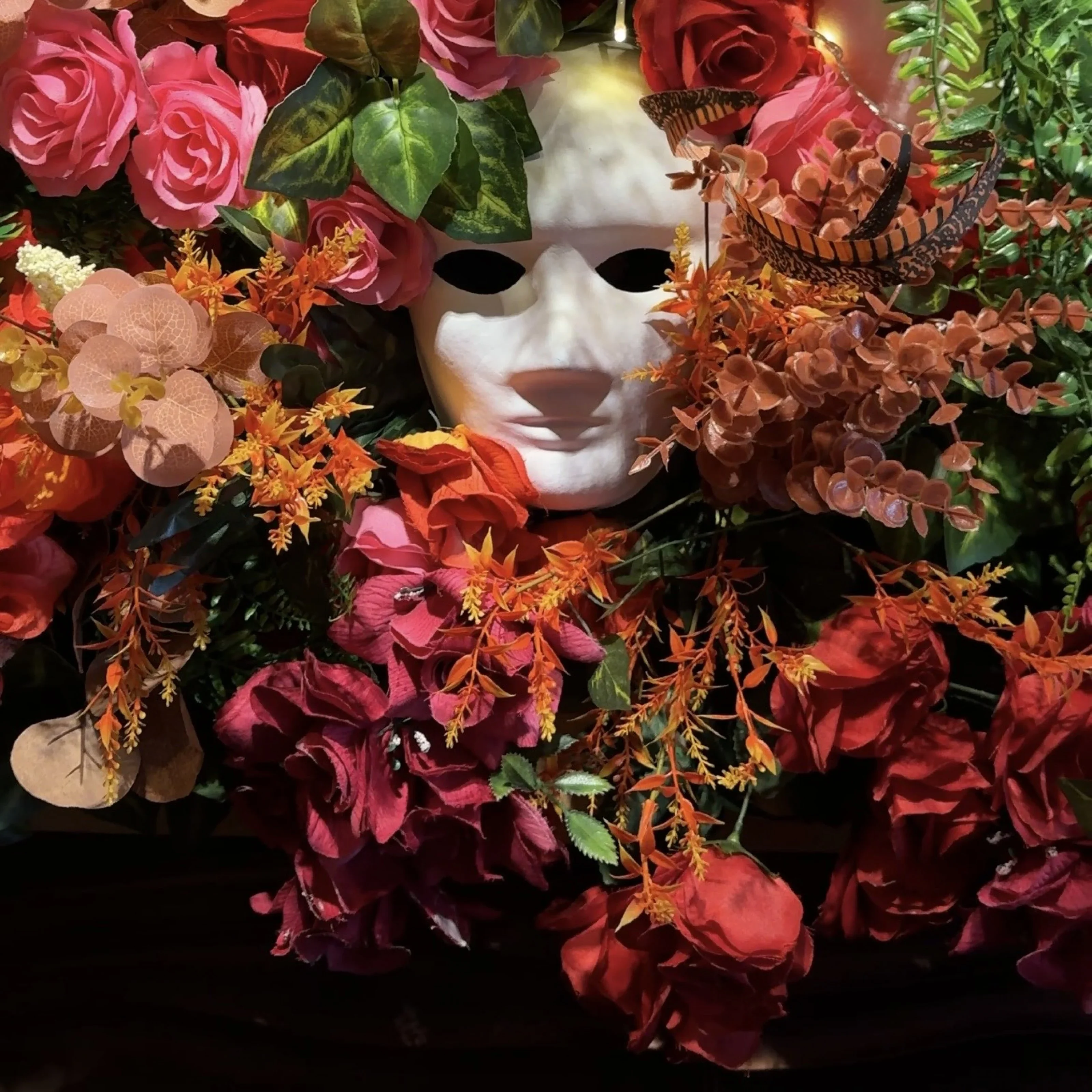 Decorative floral arrangement with a white mask