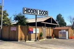 Exterior view of Hidden Door restaurant with wooden fencing