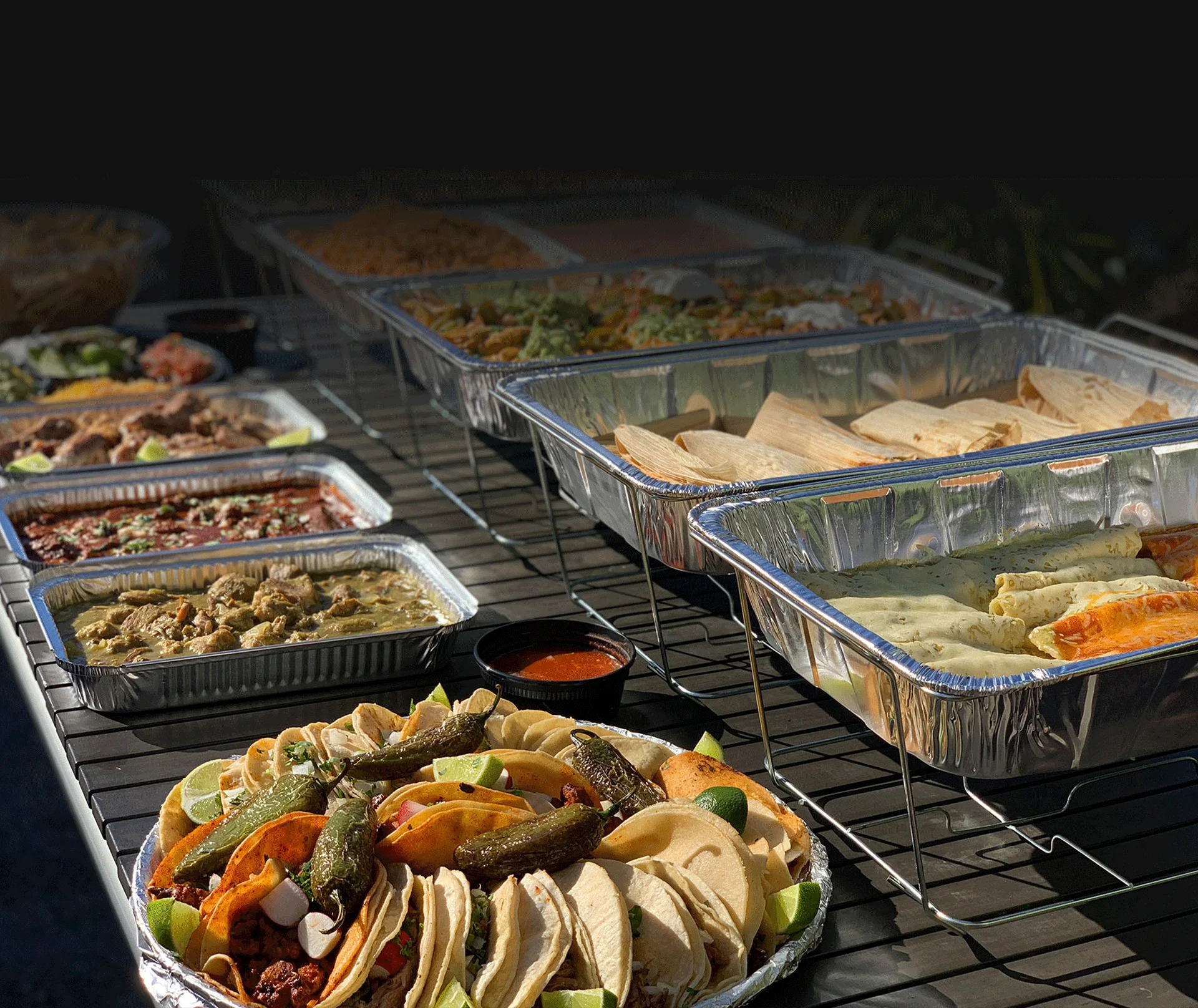 An outside table full with catering trays, buffet style 
