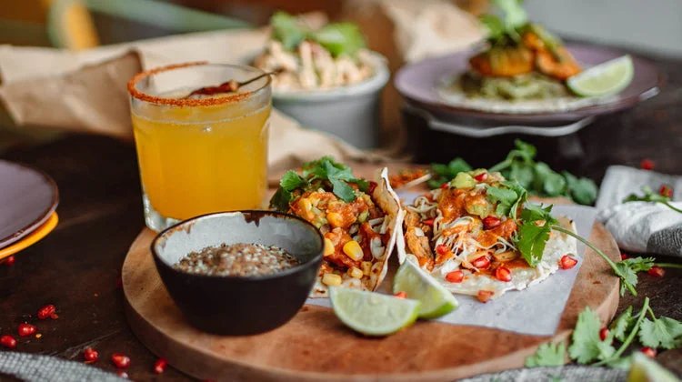 Colorful Mexican tacos with fresh toppings and a refreshing drink