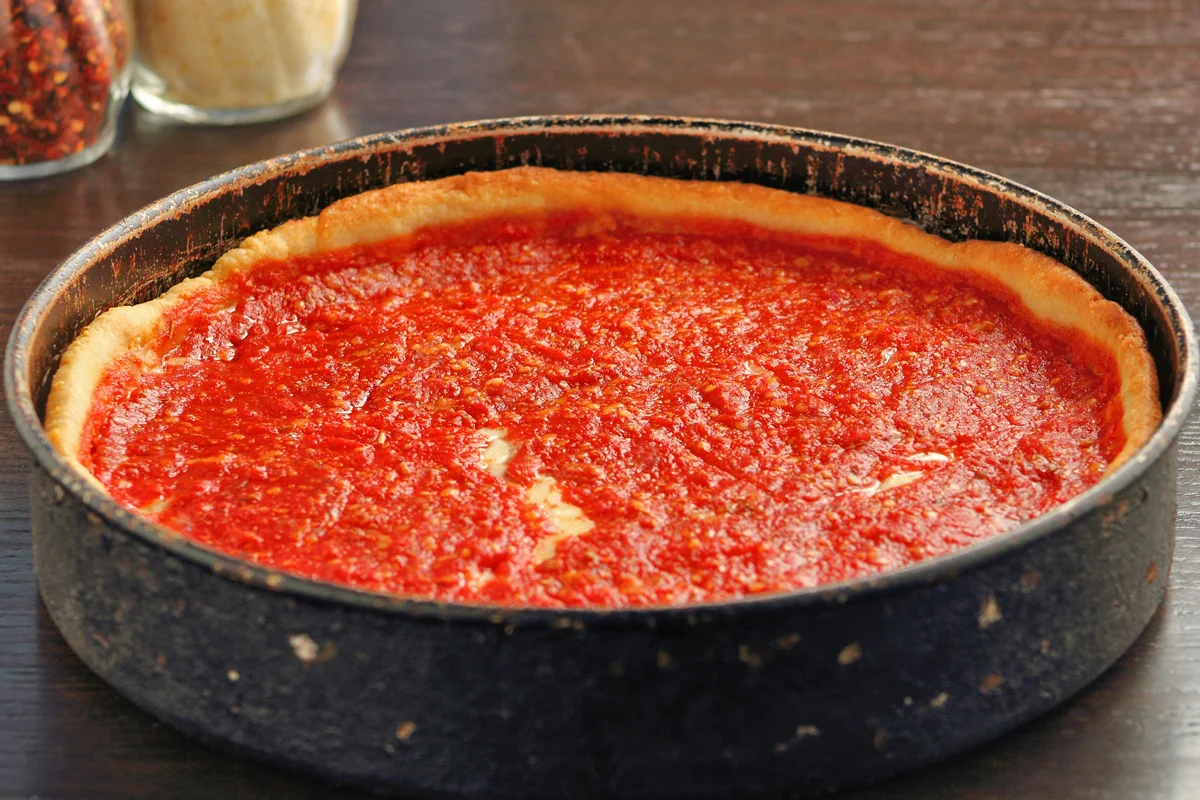 Chicago deep-dish pizza with rich tomato sauce