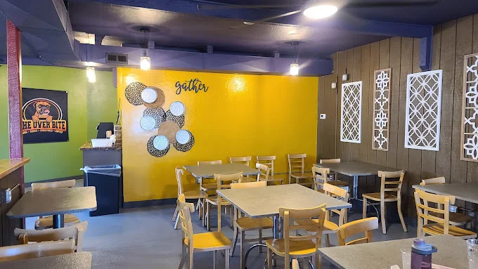 Cozy restaurant interior with yellow accent wall and wooden tables